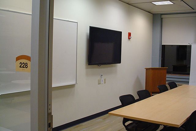 Whiteboard, lcd screen, podium, table, and chairs
